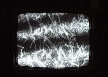 High contrast static noise on an analog screen representing the data paralysis and attention fracture caused by Uranus in Gemini.