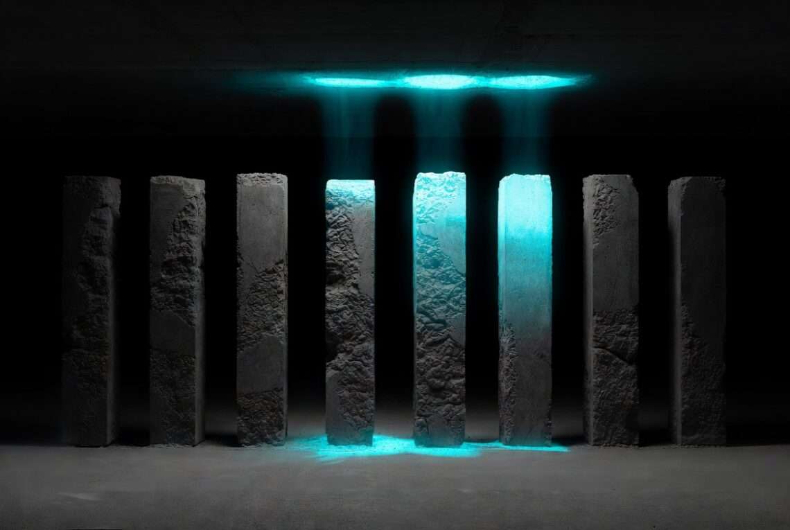 Chaldean numerology calculator letter-to-number value grid carved into brutalist concrete with active frequency rows glowing in cold blue light.